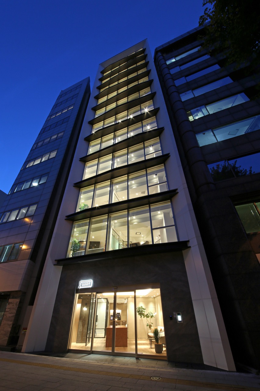 大きな窓から漏れる光が美しい夜のオフィスビル外観