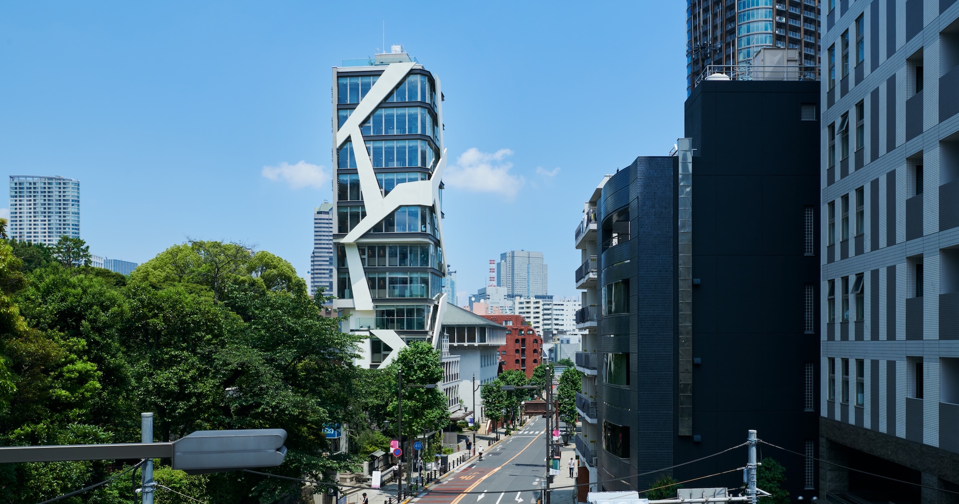 特徴的な白いファサードを持つ新築オフィスビルと周辺の街並み