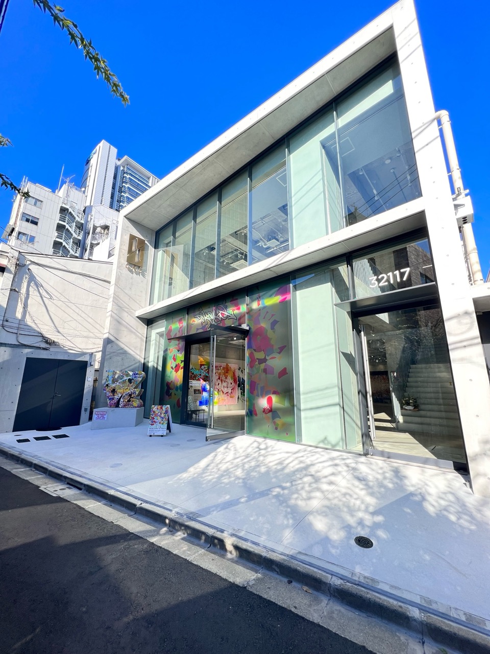 カラフルなグラフィティアートがエントランスのガラスを彩る商業ビル