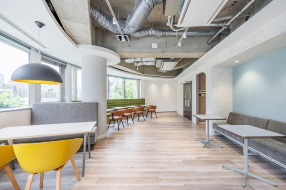 様々な座席が用意された、おしゃれで機能的なオフィス内のカフェテリア。