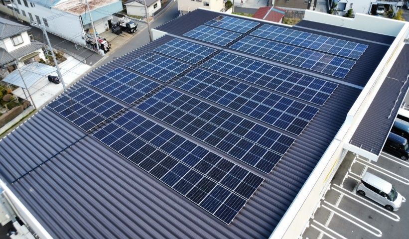 在住宅街的建築物屋頂上整然排列的太陽能板俯瞰圖。