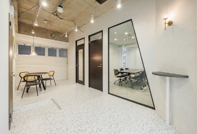 A glass-walled conference room with an industrial-style lounge area.